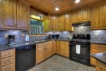 Kitchen with Granite Counter Tops and a Gas Stove with Bar Seating for 2